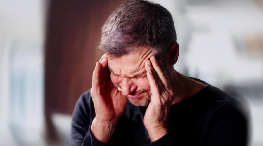 Anguished man holding hands on forehead, displaying the Effects of Methamphetamine Use on the Brain