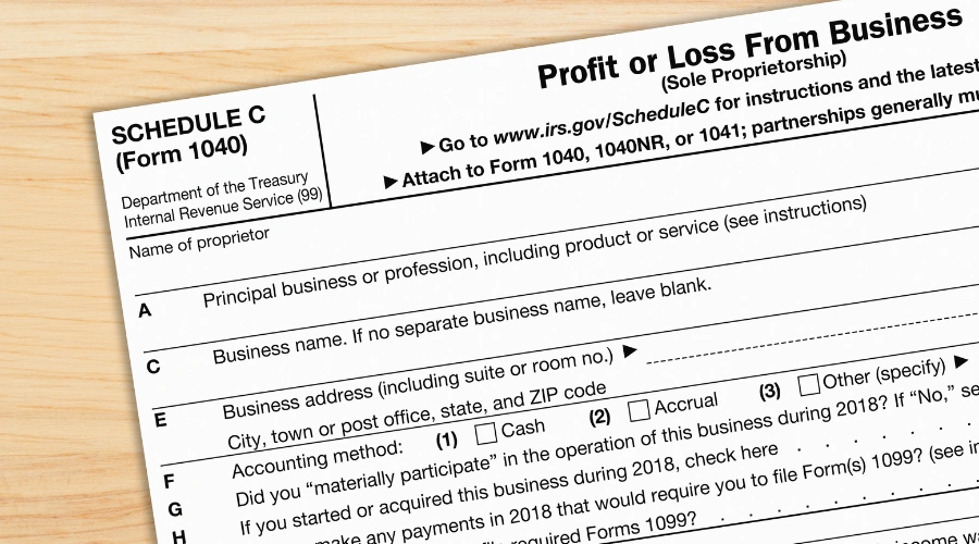 A US Federal tax 1040 Schedule C income tax form on a desk