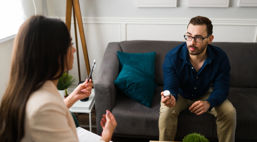 Man sitting in a therapy session talking to his female counselor