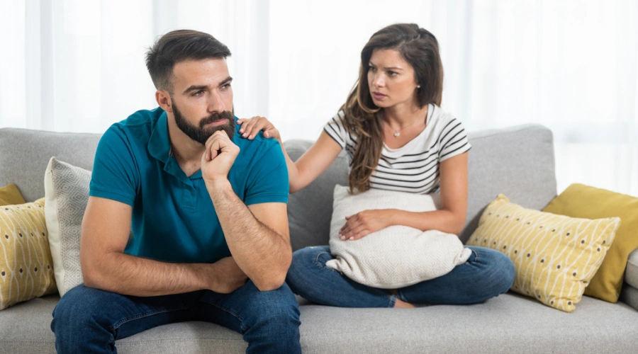 Image of a man sitting on a sofa next to his sister holding his shoulder and providing support - Path of Addiction Recovery with Relapse as Part of the Journey