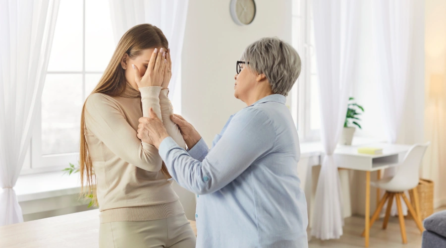 Image of a mother comforting her daughter, illustrating emotional support and healing within a family affected by generational trauma