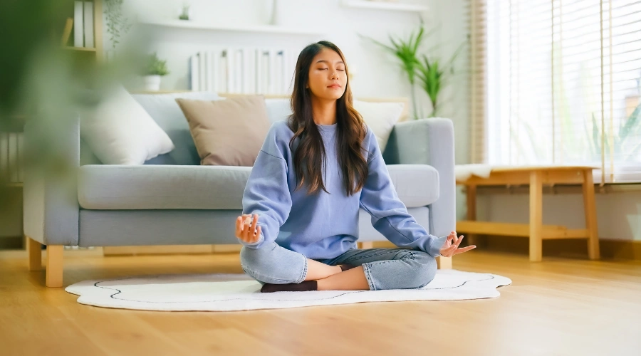 Image of woman practicing mindfulness and breathing yoga exercises to manage stress and build emotional regulation