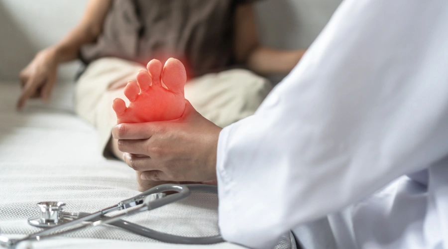 Doctor examining a patient’s legs and feet to check nerve response and muscle weakness during diagnosis of alcoholic neuropathy