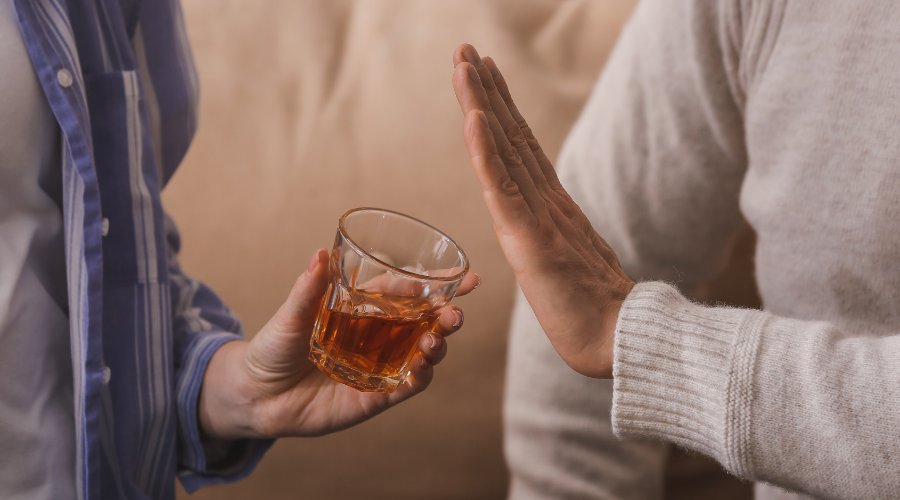 Image of a person resisting a drink, symbolizing the brain’s struggle with alcohol cravings and the process of resetting during recovery