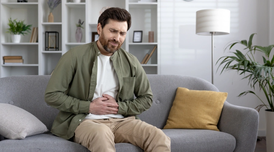 Person holding their stomach in discomfort from IBS after drinking alcohol