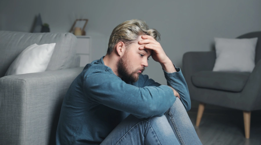 Image of a man isolating himself indoors, symbolizing avoidance of behaviors that can worsen recurring anxiety