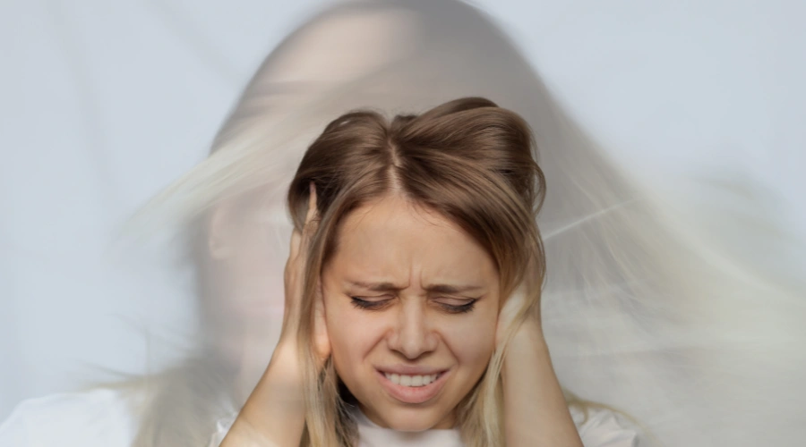 Image of a person covering their ears while appearing distressed